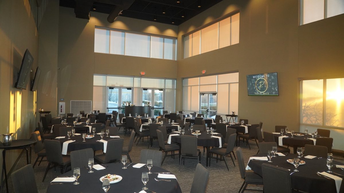 Revel Room banquet setup with Welcome to Revelance on the video wall