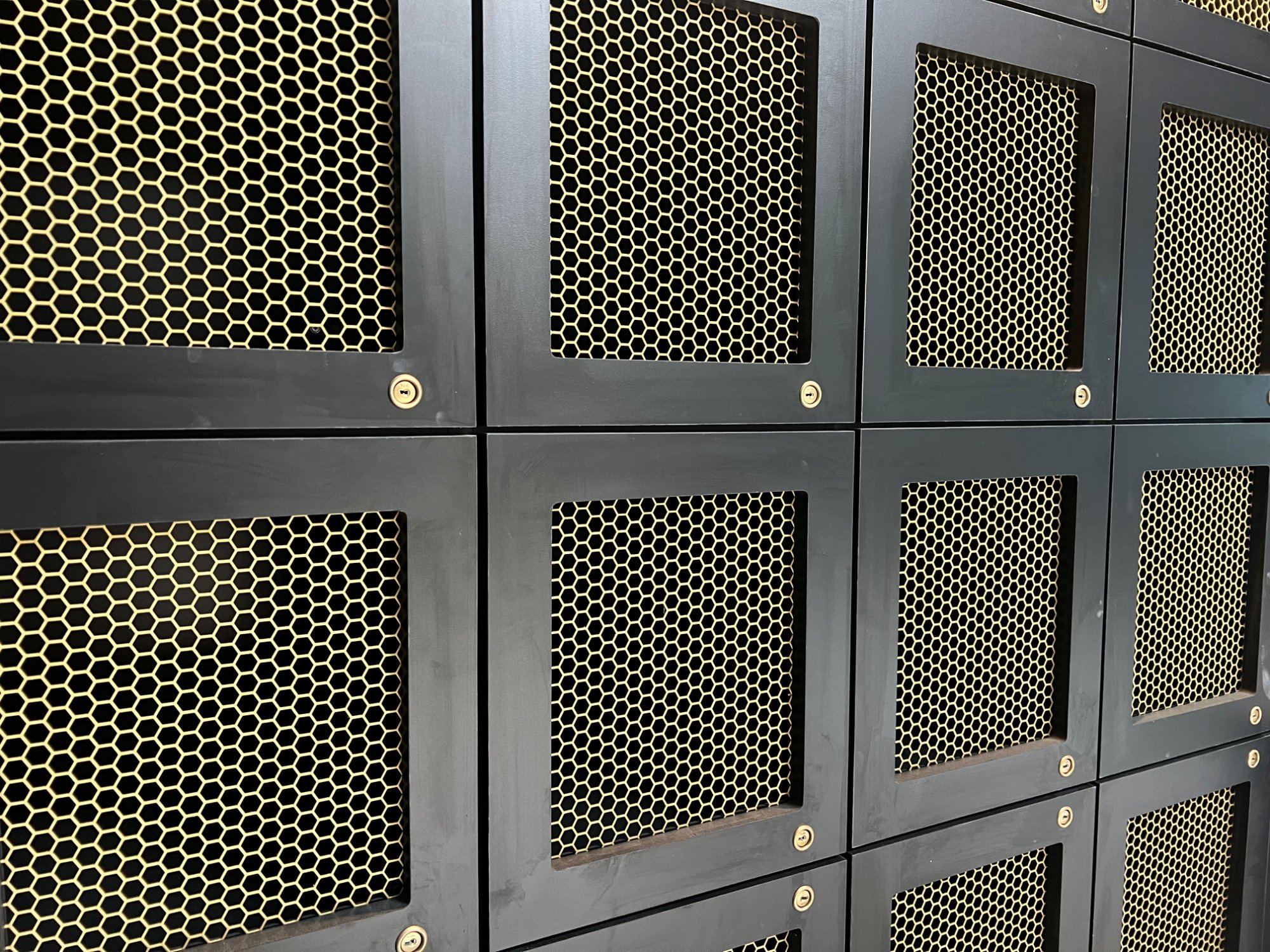 Personal bourbon lockers with gold mesh doors at the C-Suite Revelance Mason Ohio