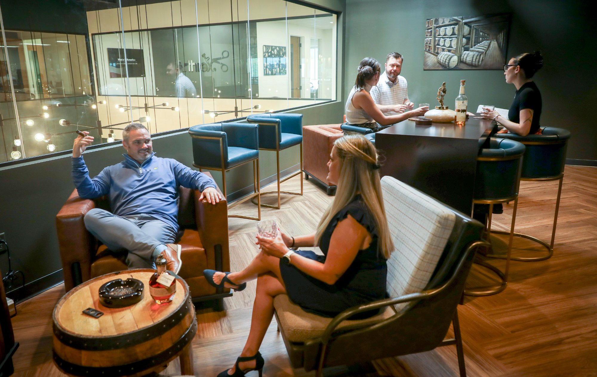 Guests enjoying cigars and bourbon in the C-Suite private lounge at Revelance