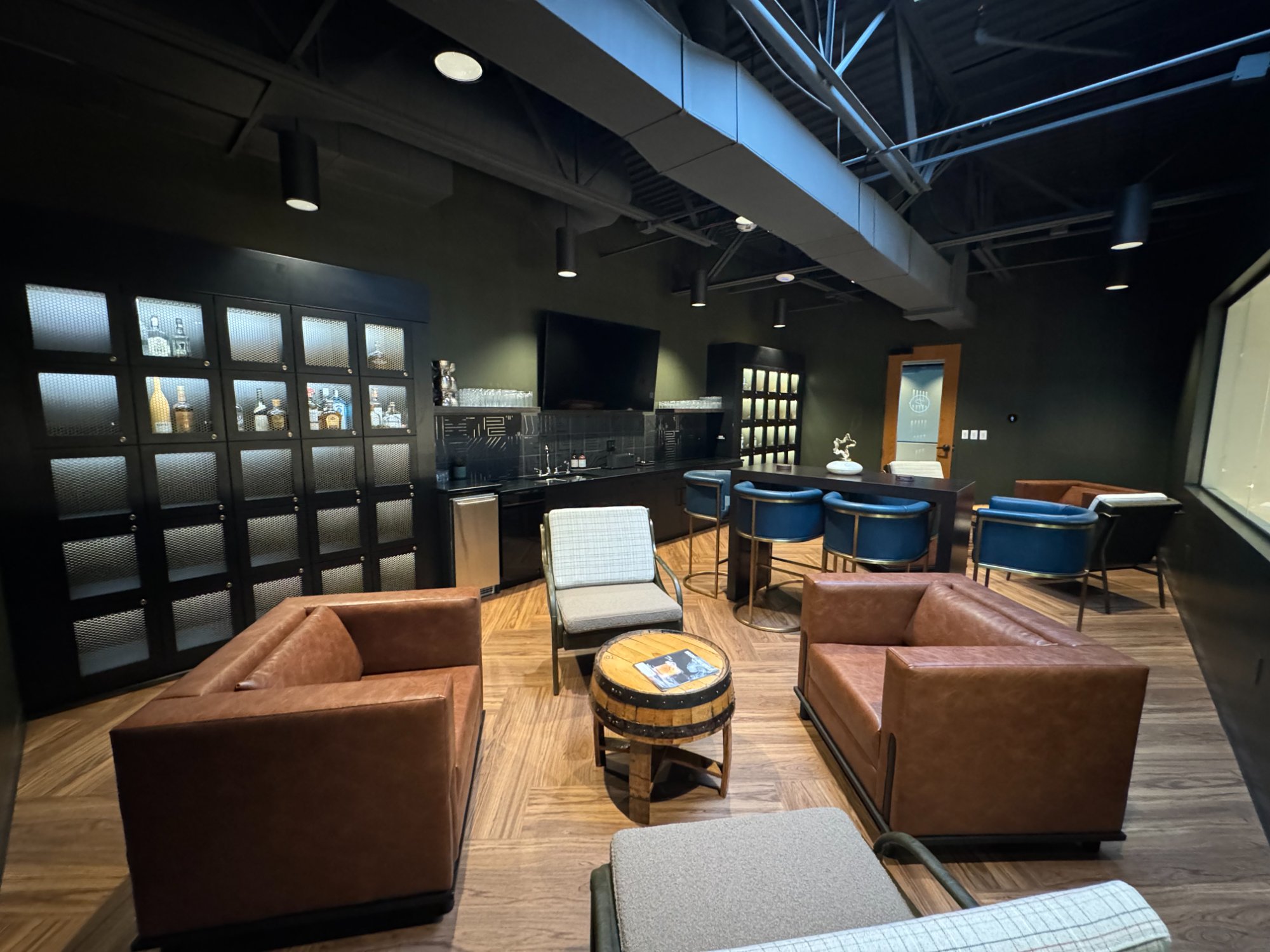 The C-Suite executive lounge at Revelance — full room view with bourbon lockers, seating, and bar