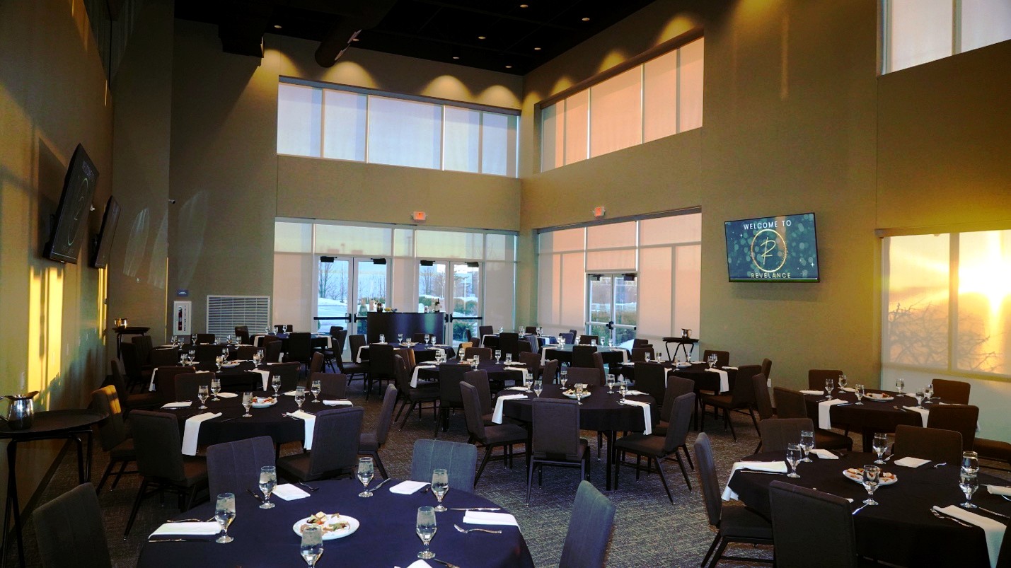 Revel Room banquet setup with two-story windows and golden light